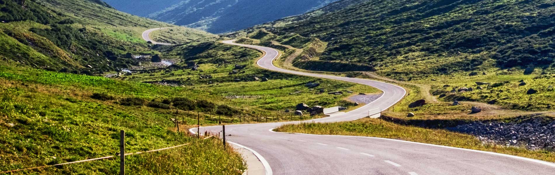 A long winding road in a valley between mountains.