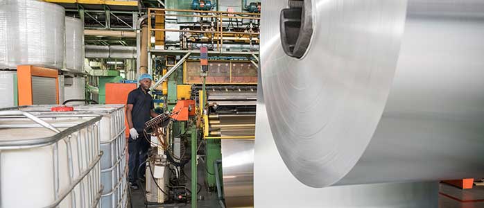 A large roll of aluminum at the beginning of the beverage can bottling line