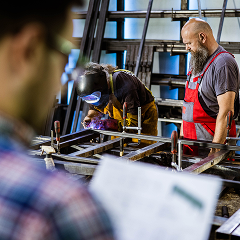 An over-shoulder shot of a man reviewing two welders