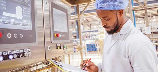 A man with a clipboard checking machinery