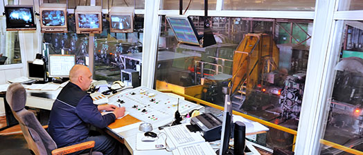 A man sitting in the control room for a manufacturing facility