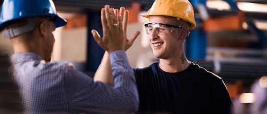 Two men in hardhats high-fiving
