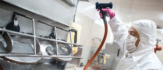 A man spraying down industrial machinery