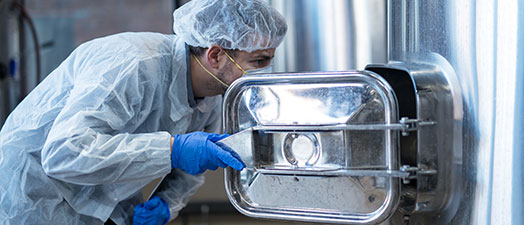 A man checks an industrial tank