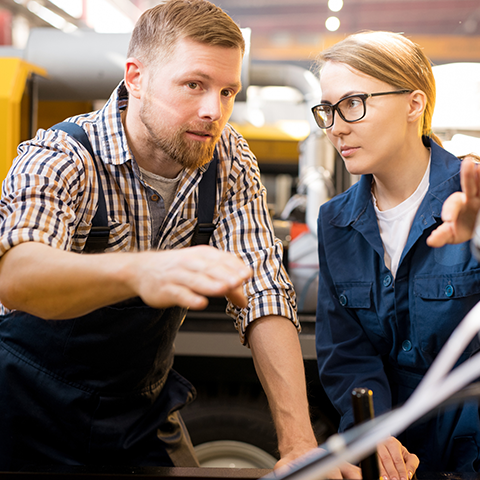 Two people discussing and pointing at something out of view