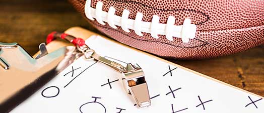 A football, clipboard, and whistle