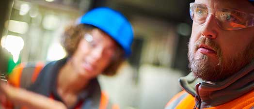 Two construction workers looking off screen