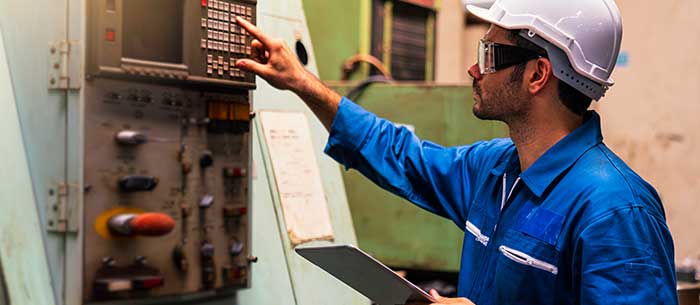 Machine operator reading work instructions from tablet computer