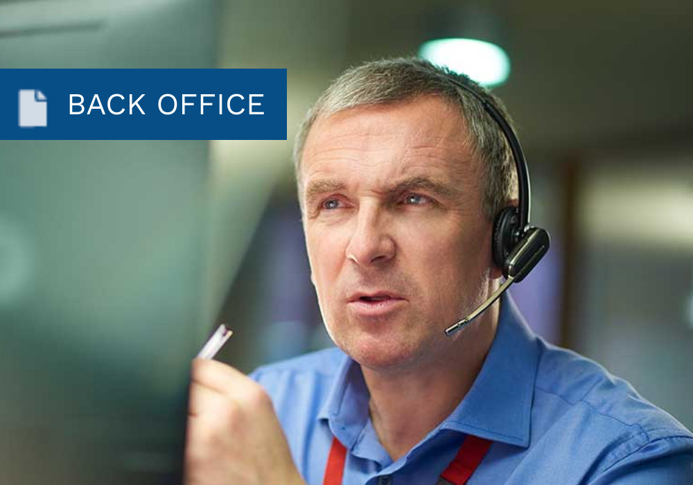 Man with headset working on a desktop computer